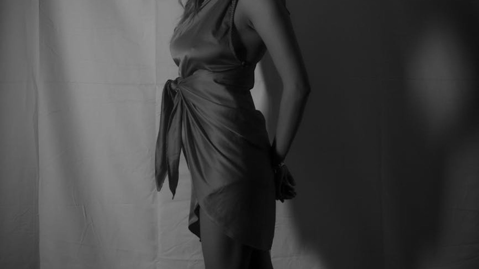 Atmospheric yoga studio with soft orange lighting and shadows.