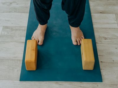 Roll of a black yoga mat and a wooden block.